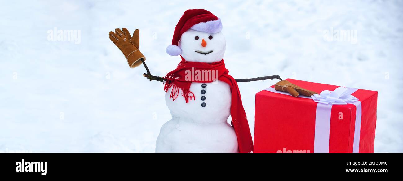 Schneemann mit großem Geschenk. Frohe Weihnachten und eine Grußkarte zum guten neuen Jahr. Festliche Kunst Grußkarte mit Schneemännern . Geschenk präsentiert Konzept. Schneemann Stockfoto