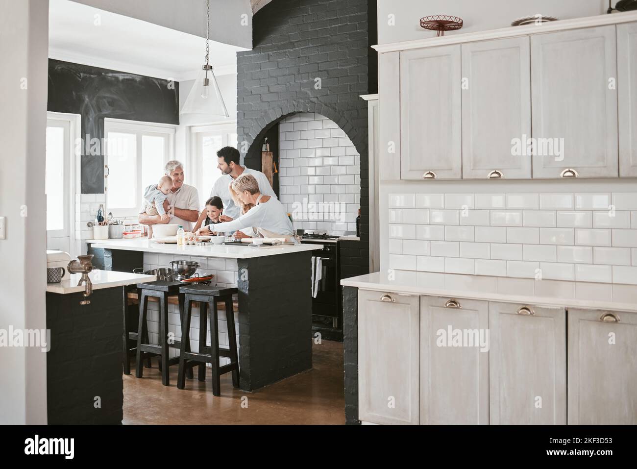 Große Familie, Backen und Lernen zusammen in der Küche für Spaß, Bindung und Qualität Zeit zu Hause. Eltern, Großeltern und Kinder kochen Rezept mit Stockfoto