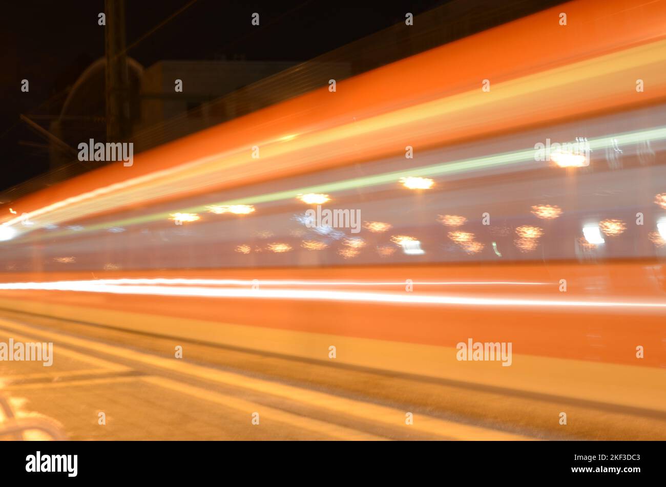 Zug, der mit hoher Geschwindigkeit durch einen Bahnhof fährt Stockfoto