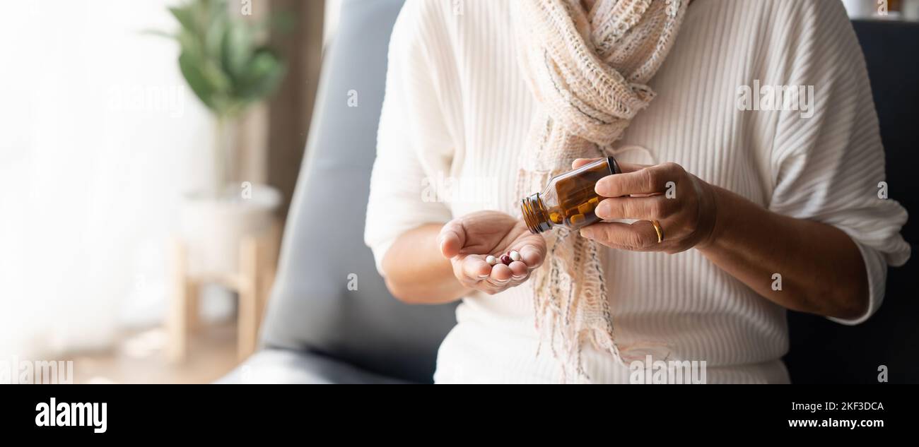 Nahaufnahme reife Frau, die Pillen aus der Flasche, Nahrungsergänzungsmittel oder Antibiotika, ältere Frau bereitet sich auf Notfallmedizin, chronische Krankheit Stockfoto