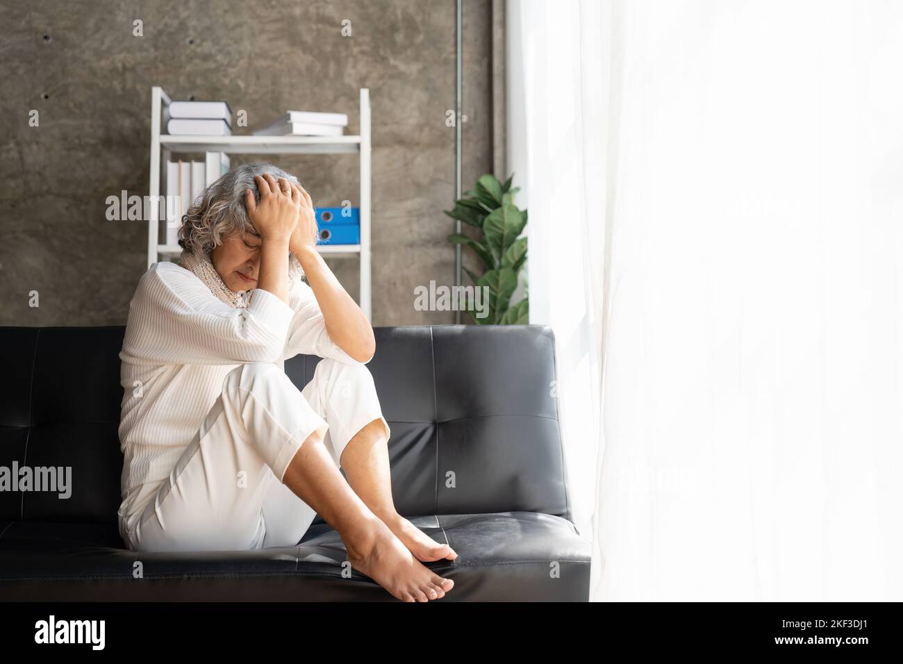 Traurig müde krank krank einsam enttäuscht kaukasisch alte ältere Frau Großmutter sitzt auf dem Sofa Couch, Gefühl nostalgisch, Schmerzen, fehlt Stockfoto
