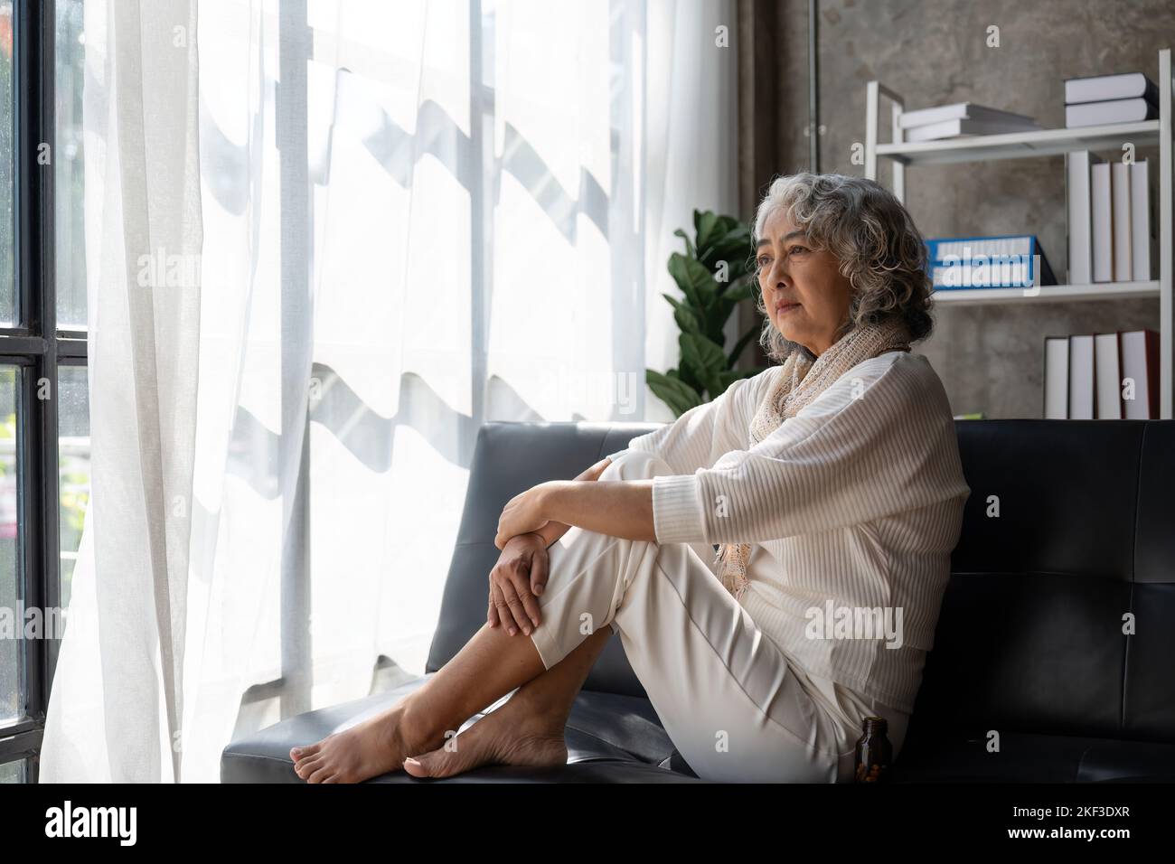 Traurig müde krank krank einsam enttäuscht kaukasisch alte ältere Frau Großmutter sitzt auf dem Sofa Couch, Gefühl nostalgisch, Schmerzen, fehlt Stockfoto