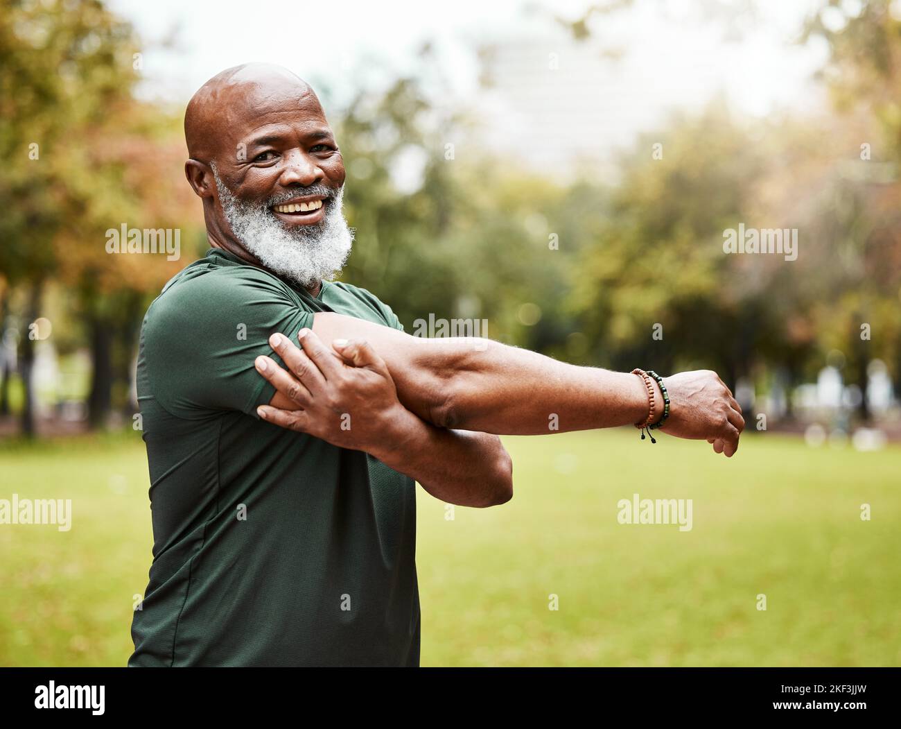Senior Fitness, Bewegung und schwarzer Mann Stretching im Freien im Park für Energie, Gesundheit und Wellness im Ruhestand. Porträt, Gesicht und Lächeln des Mannes in Stockfoto