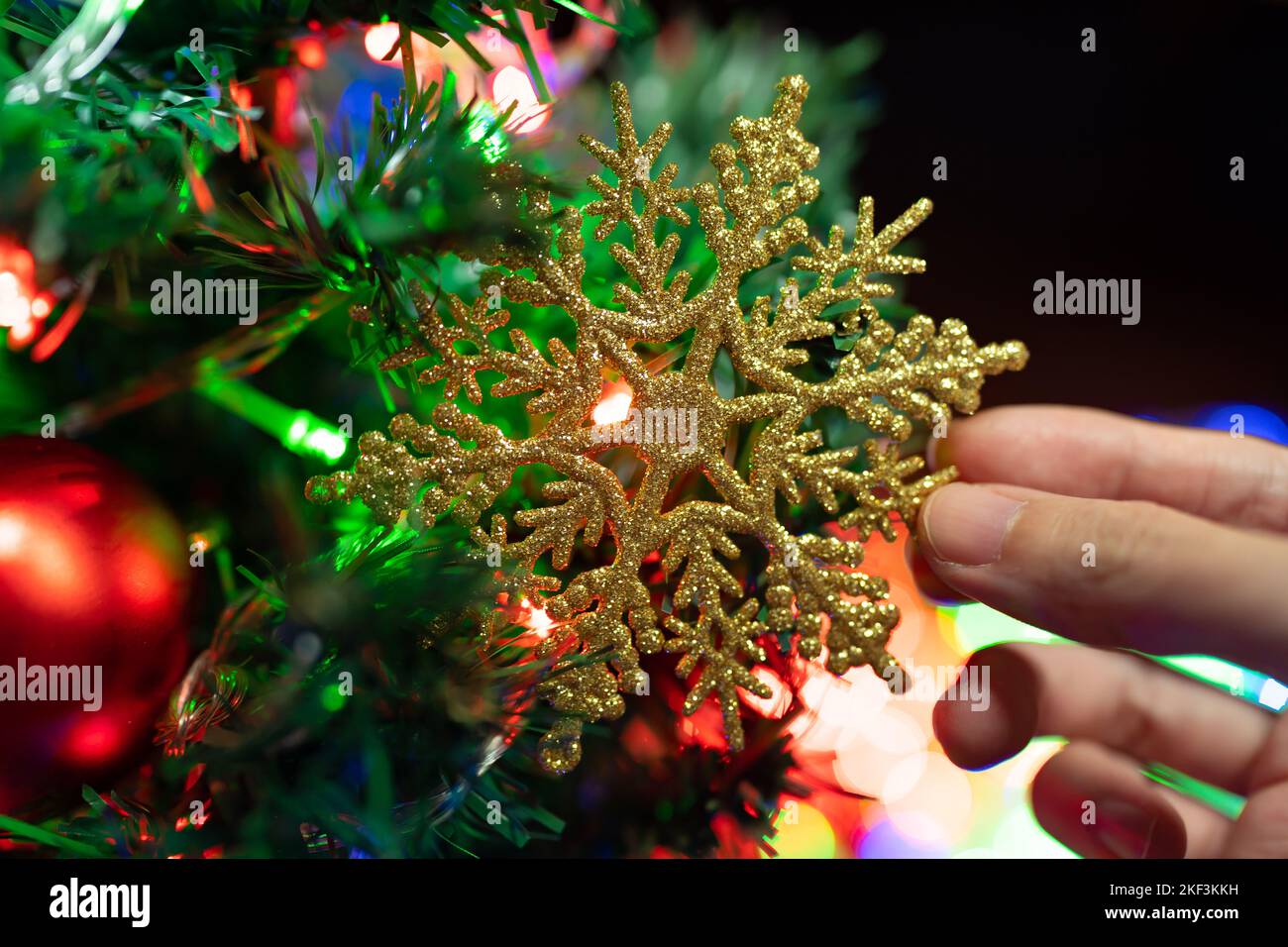 Weihnachtsbaum mit glitzernder Schneeflocke dekorieren Stockfoto