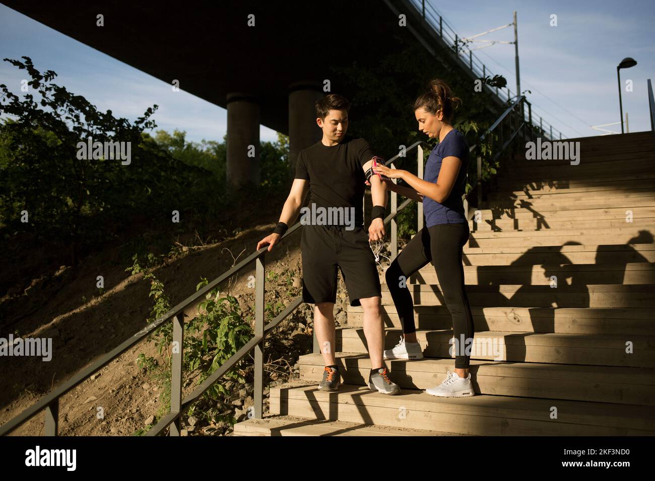 Frau hilft Mann mit Handy-Armband Stockfoto