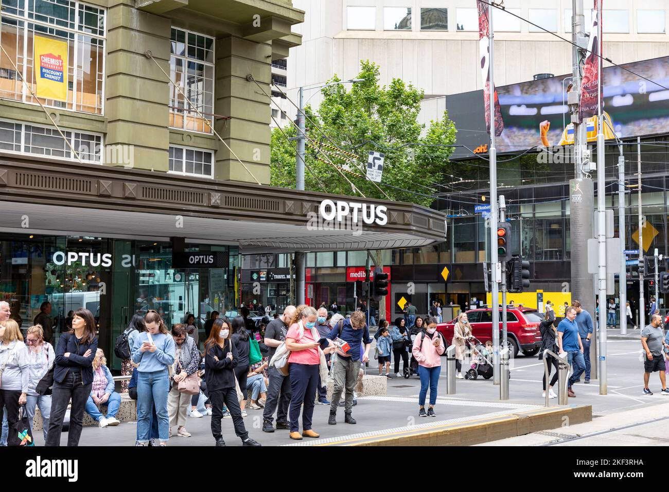 Optus Telekommunikationsgeschäft in der Bourke Street in Melbourne Victoria, Leute warten an der Straßenbahnhaltestelle, Victoria, Australien Stockfoto