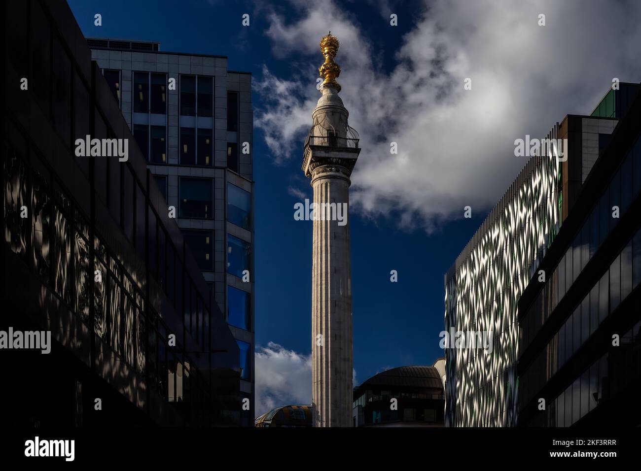 Ein ungewöhnliches und dramatisches Foto des Denkmals mit hervorragenden Reflexionen in einem Bürogebäude auf beiden Seiten der Straße. Stockfoto