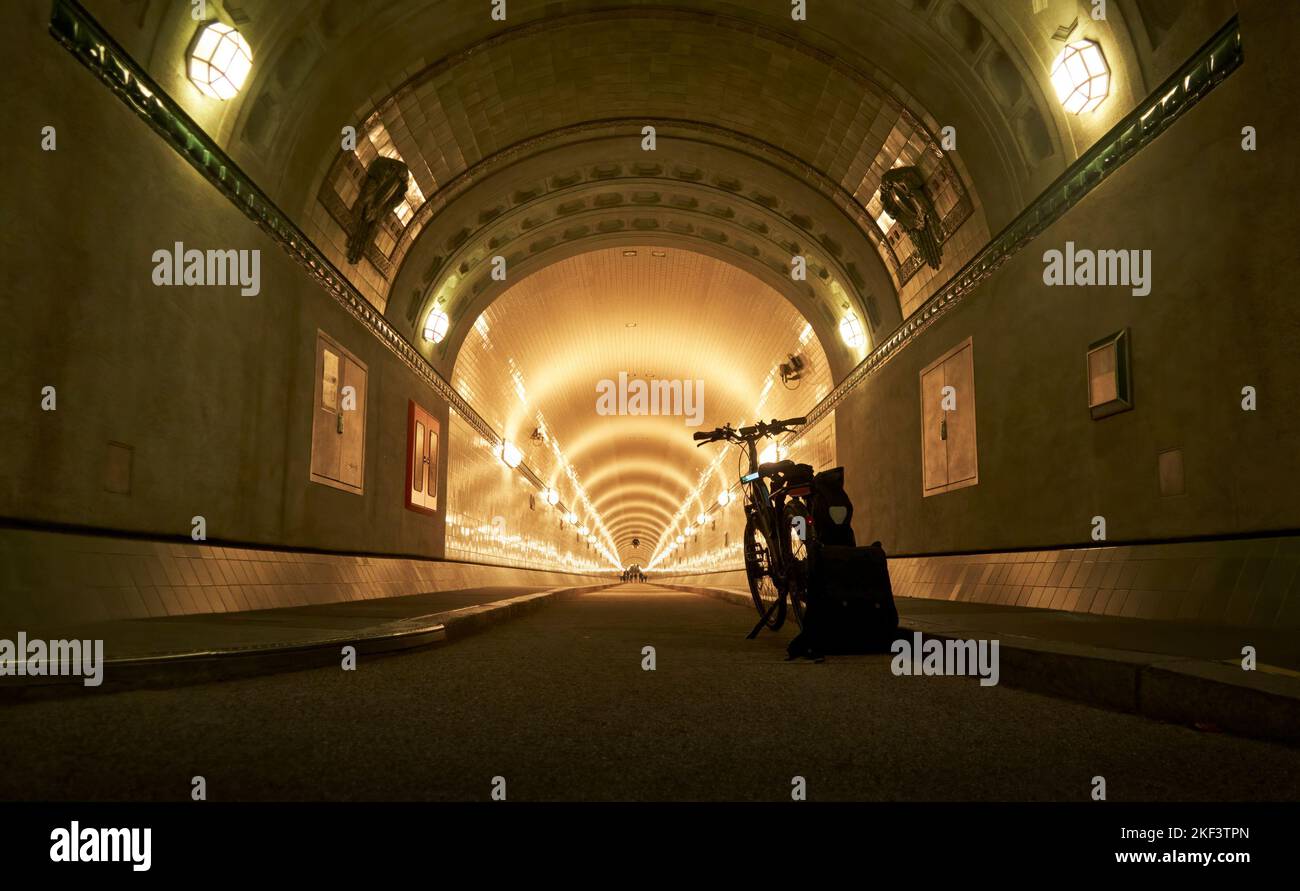 Schwarze Fahrradständer am Anfang des dunklen Tunnels mit Lichterreihen, Elbtunnel in Hamburg, Fahrradtour Deutschland Stockfoto