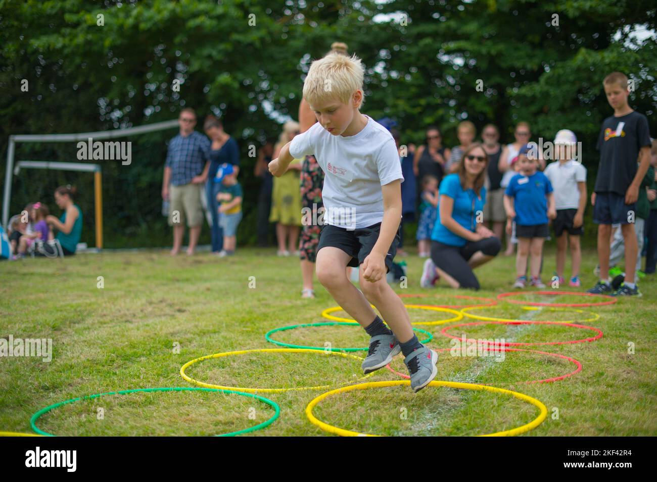 Ein kleiner Junge, der an einem Sporttag in der Grundschule teilhat Stockfoto