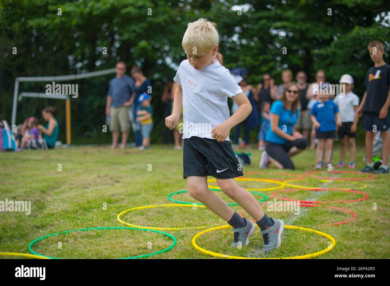 Ein kleiner Junge, der an einem Sporttag in der Grundschule teilhat Stockfoto