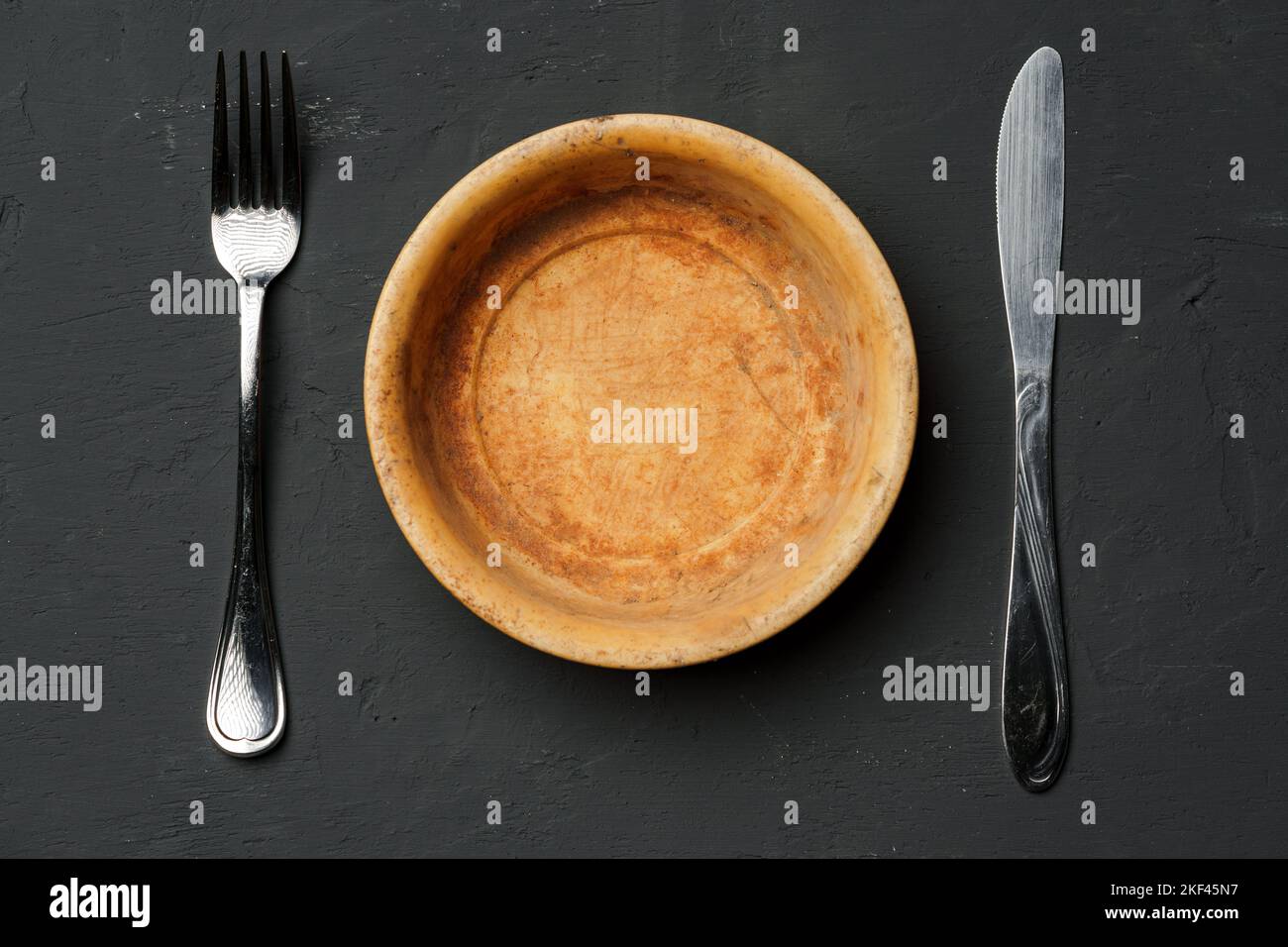 Leere Schüssel auf dunklem Hintergrund mit Kopierplatz Stockfoto