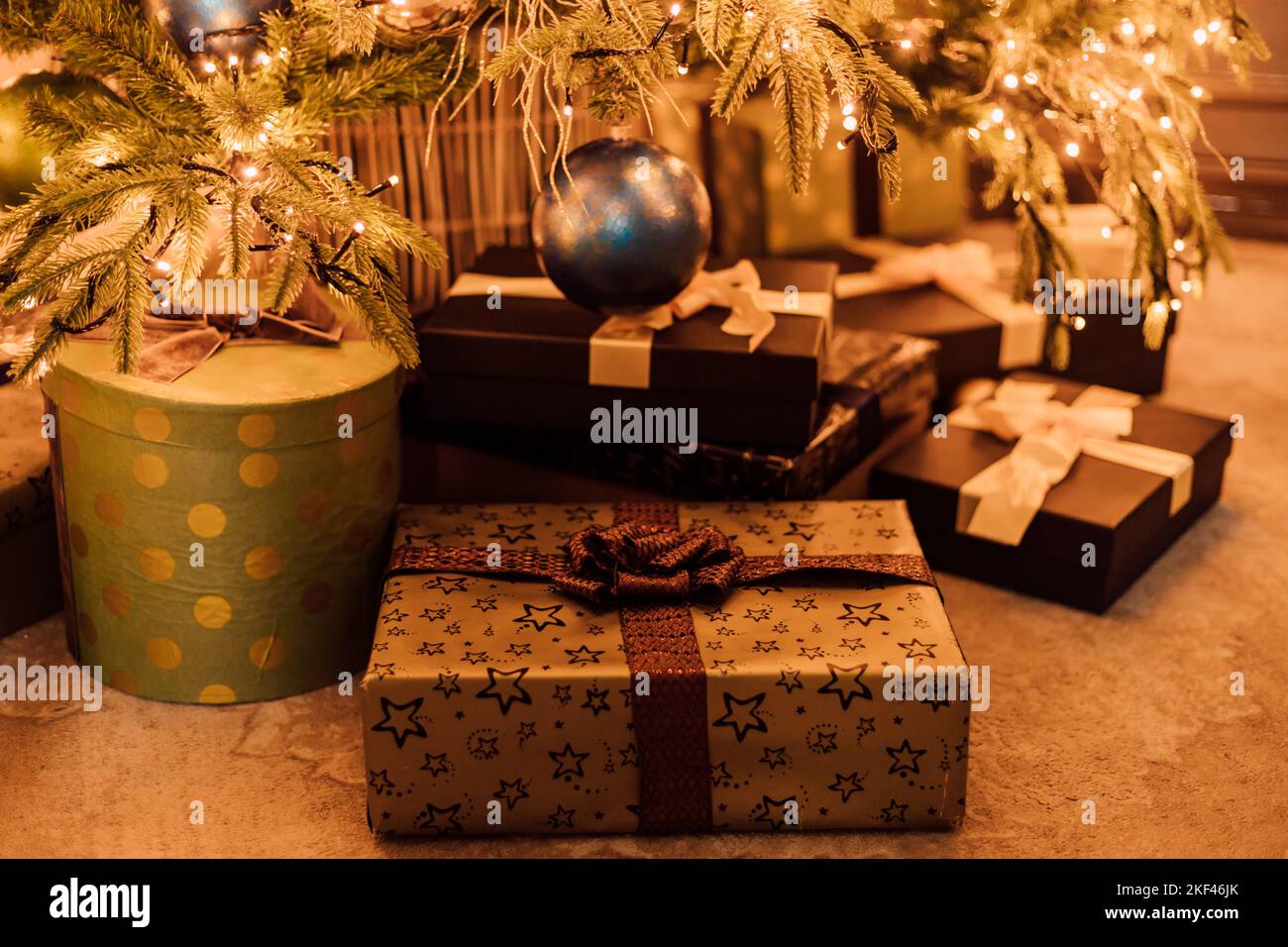 Geschenkschachteln unter dem Weihnachtsbaum in braun. Heiligabend Stockfoto