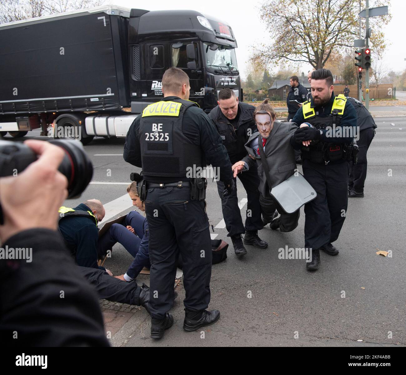 Berlin, Deutschland. 16.. November 2022. Polizisten tragen einen Aktivisten der Umweltgruppe "Letzte Generation" an einer Kreuzung in der Landsberger Allee. Zuvor hatten die Aktivisten dort eine Kreuzung blockiert. Es gab erhebliche Verkehrsbehinderungen. Quelle: Paul Zinken/dpa/Alamy Live News Stockfoto