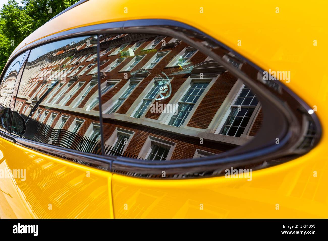 Ein schönes gelbes Lamborghini-Auto spiegelt die beeindruckenden traditionellen Backsteingebäude in diesem hochklassigen londoner Grosvenor Square wider Stockfoto