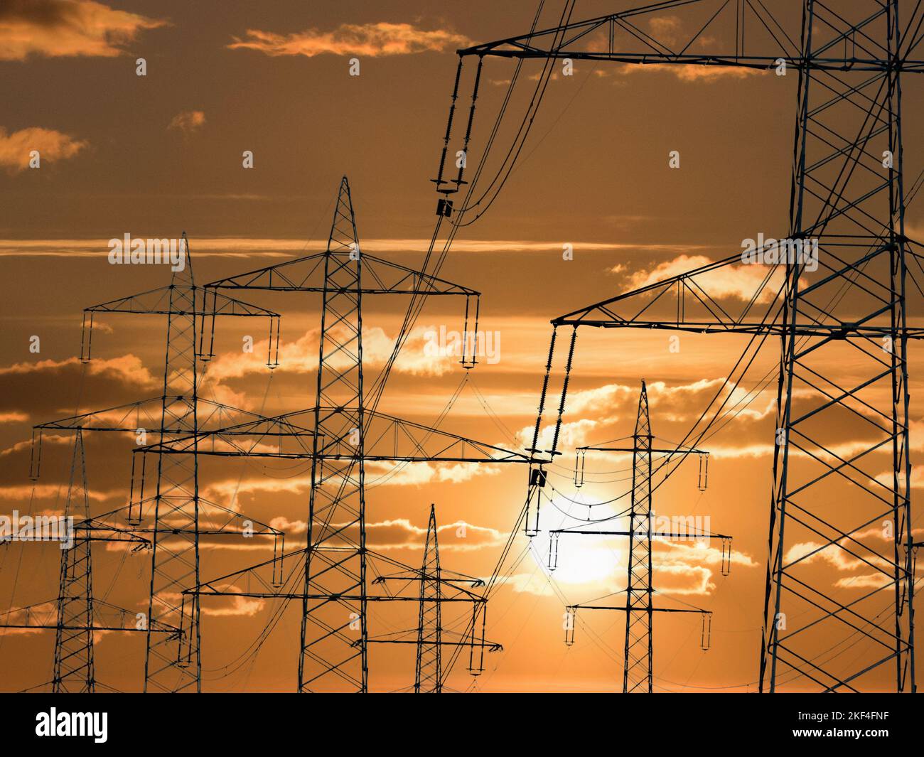 Der Mast einer Hochspannungsleitung für elektrischen Strom vor Sonnenuntergang, Alternative Energie, Stockfoto