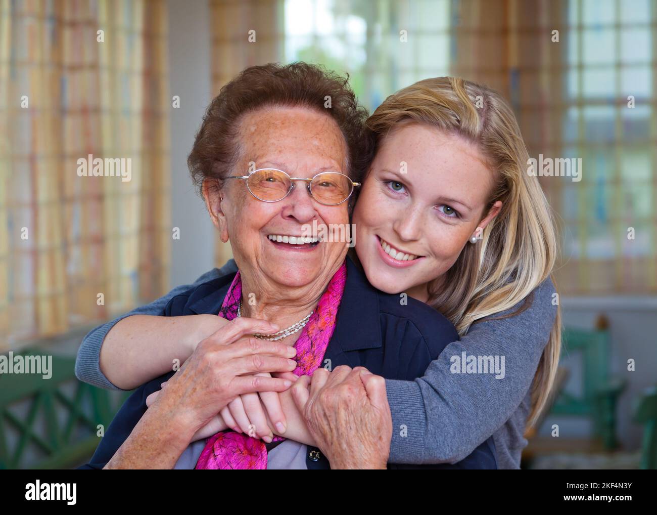 Ein Enkel besucht ihre Großmutter. Spass und Freude bei der Umarmung, Enkelin 30, 35, Jahre, Grossmutter 75, 80, Jahre, Enkelin, Stockfoto