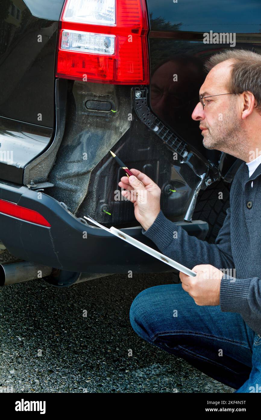 KFZ-Sachverarbeiter einer Versicherung begrueft einen Schaden am Auto. Autoversicherung, Regulierung, Kulanz, Reparatur, Versicherungsdschaden, Unf Stockfoto