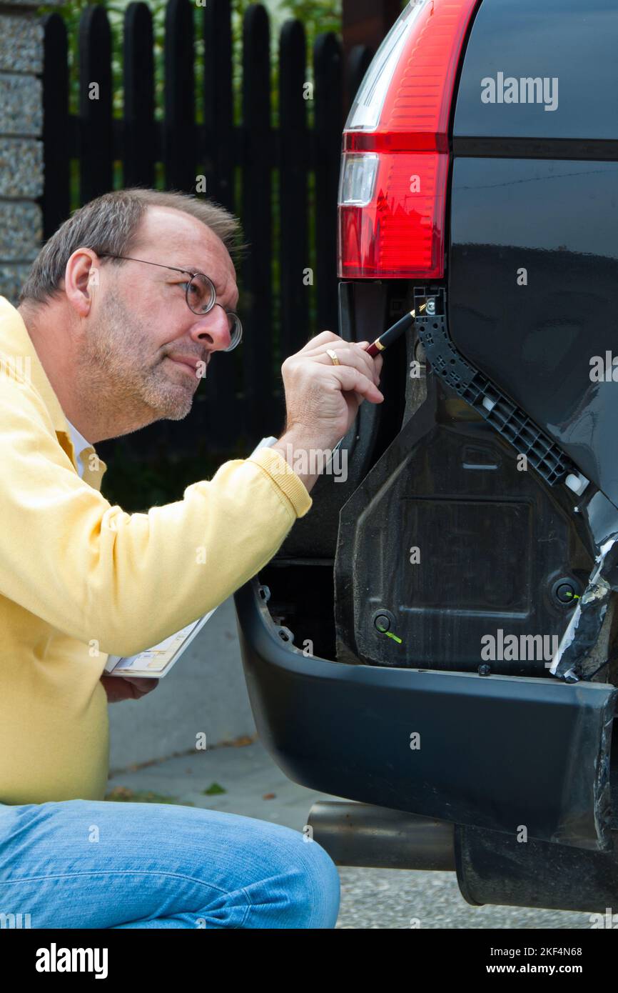 KFZ-Sachverarbeiter einer Versicherung begrueft einen Schaden am Auto. Autoversicherung, Regulierung, Kulanz, Reparatur, Versicherungsdschaden, Unf Stockfoto