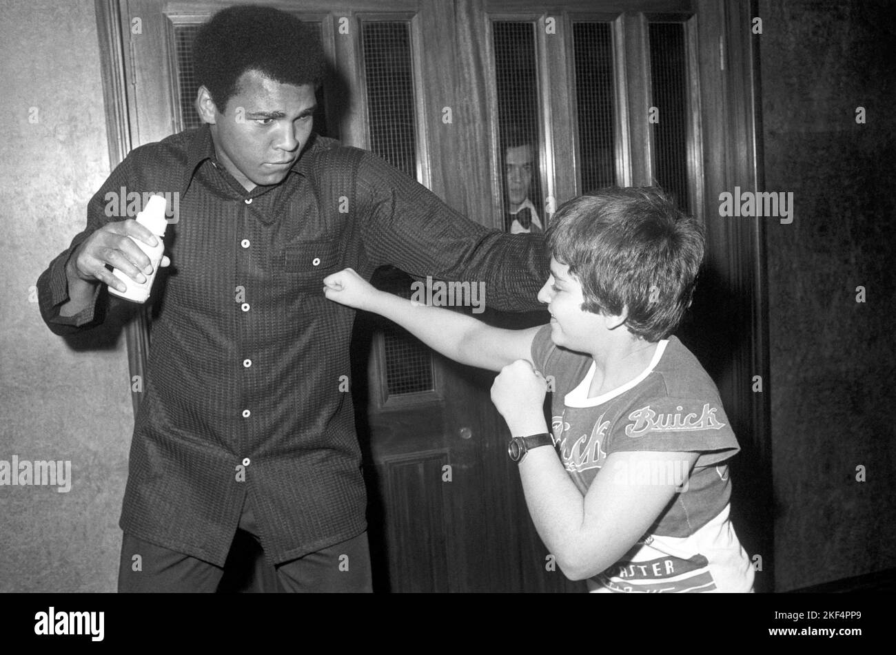 Der Schwergewichtsweltmeister Muhammad Ali (l.) steht mit einem jungen