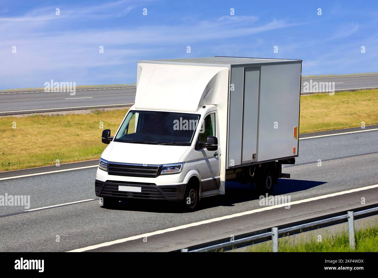 Weißlicht-LKW für den Regionalverkehr und schnelle Lieferungen auf der Autobahn an einem Sommertag. Stockfoto