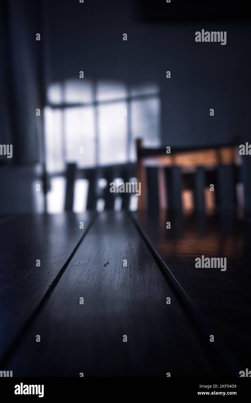 Geringes Sonnenlicht mit Schatten an einer Wand mit Tisch und Stuhl Stockfoto