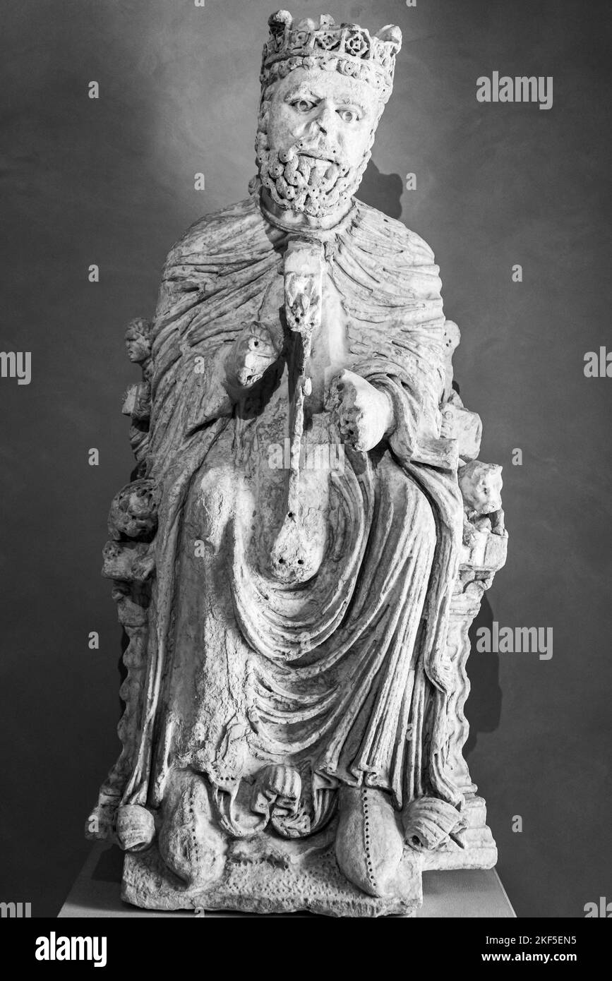 Schwarz-weißes Foto einer Statue in Ruinen, die einen älteren mittelalterlichen König darstellt, der auf dem Thron sitzt Stockfoto