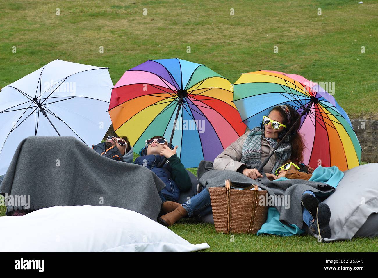 Familienpicknick mit Regenbogenschirmen Stockfoto