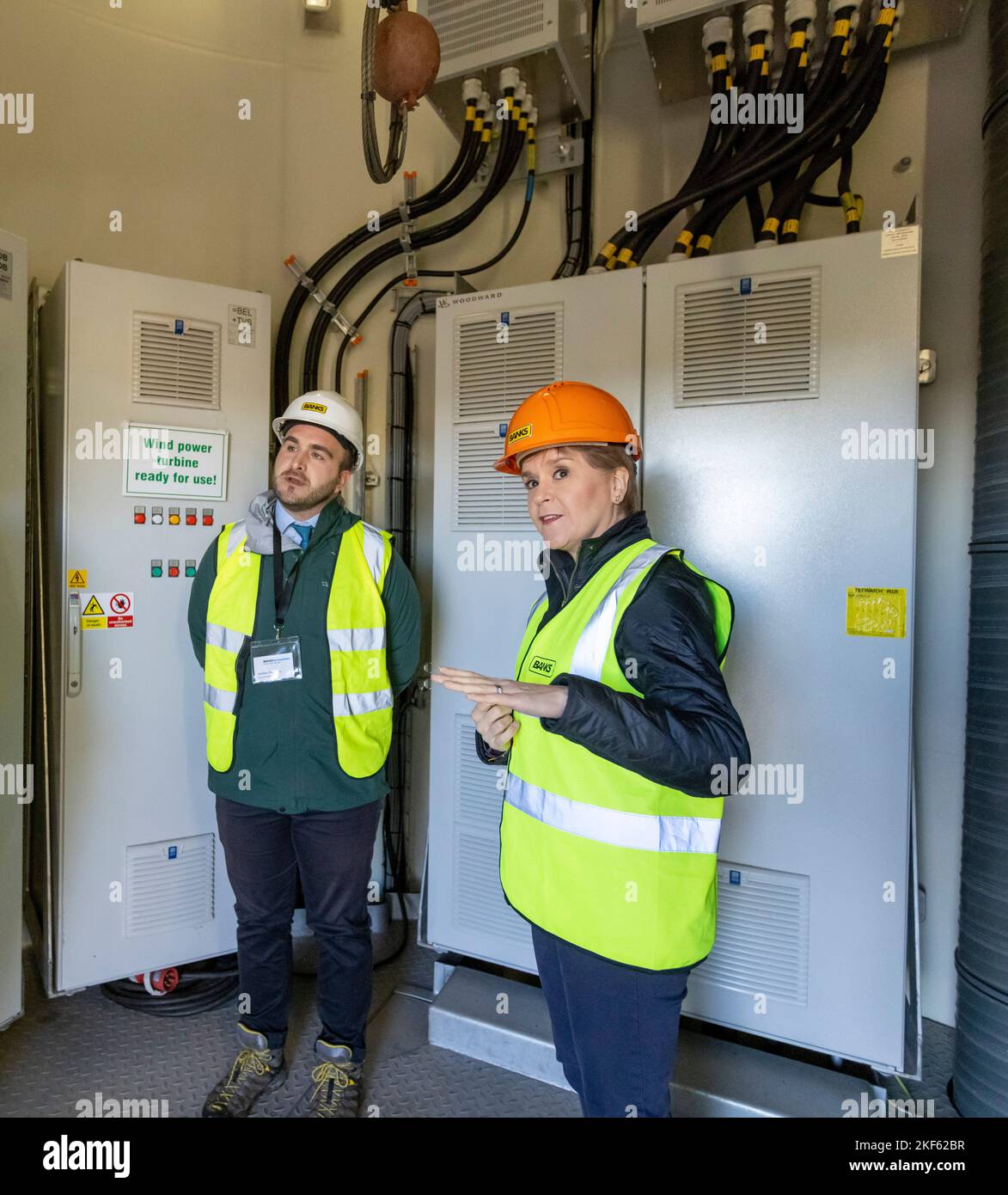 Erste Ministerin Nicola Sturgeon in einer Turbine mit Gordon Thomson, Leiter der Projekte bei Banks Renewables, während sie den Windpark Kype Muir in der Nähe von Strathaven, South Lanarkshire, besucht, um die Netzverbindung der höchsten Windkraftanlage Großbritanniens zu markieren. Bilddatum: Mittwoch, 16. November 2022. Stockfoto