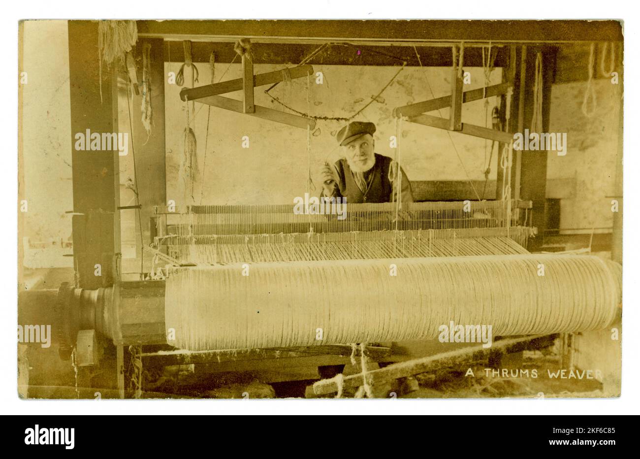 Originale edwardianische Postkarte eines älteren Schotten, der ein Thrums Weaver ist - wahrscheinlich ein Hüttenarbeiter, der von zu Hause aus an einem Holzstrauß arbeitet, Handloommaschine, vielleicht Rugmaking. Schübe sind Abfälle aus der Teppichweberei, sie waren billig, also wird dieser Mann wahrscheinlich arm sein. Die Postkarte ist datiert/am 5. Februar 1907 aus Kirriemuir, Angus, Schottland, Stockfoto