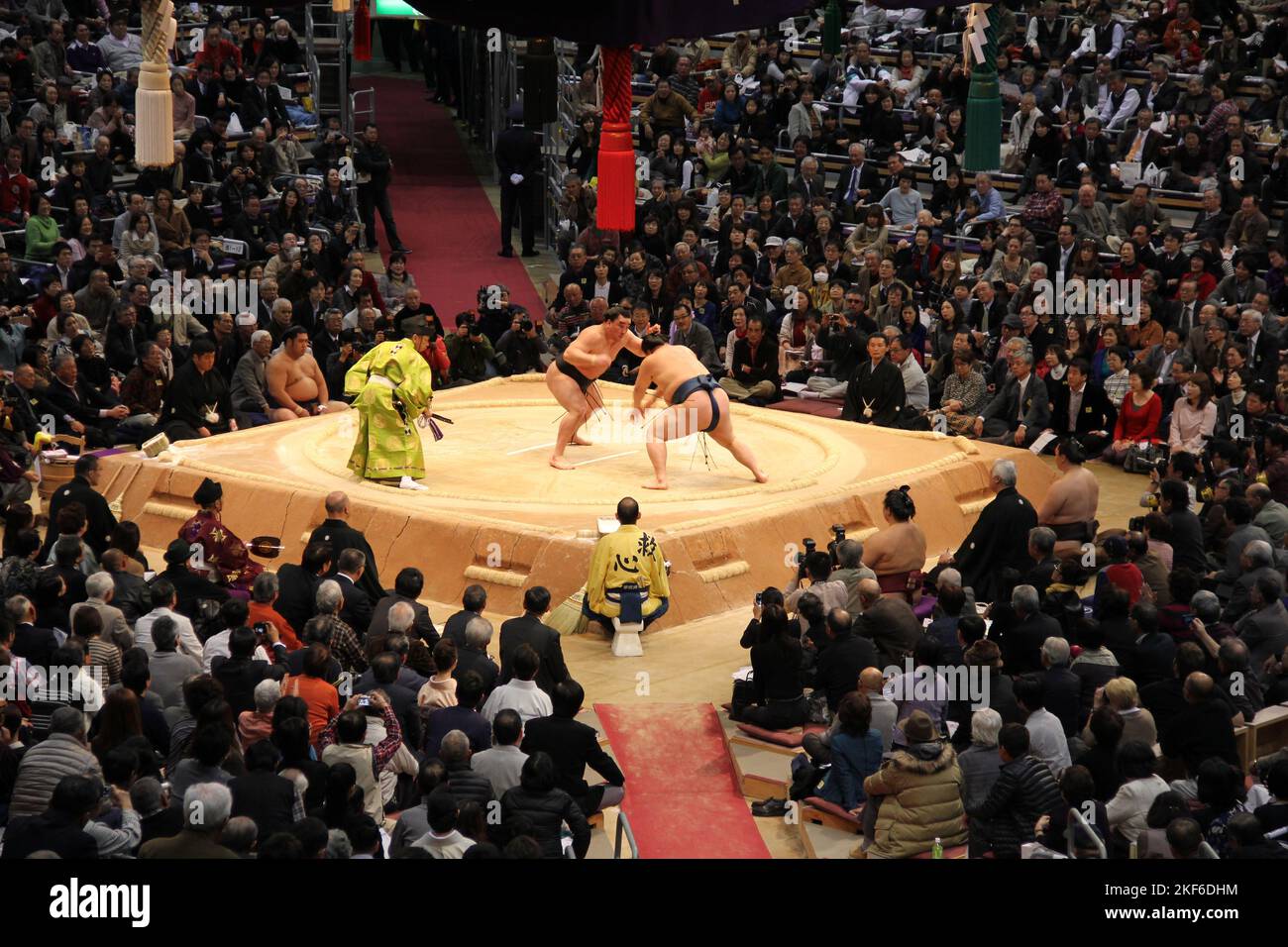 In Fukuoka treten Sumo-Wrestler mit einem Weitwinkelschuss vor Publikum in einer Meisterschaft an Stockfoto