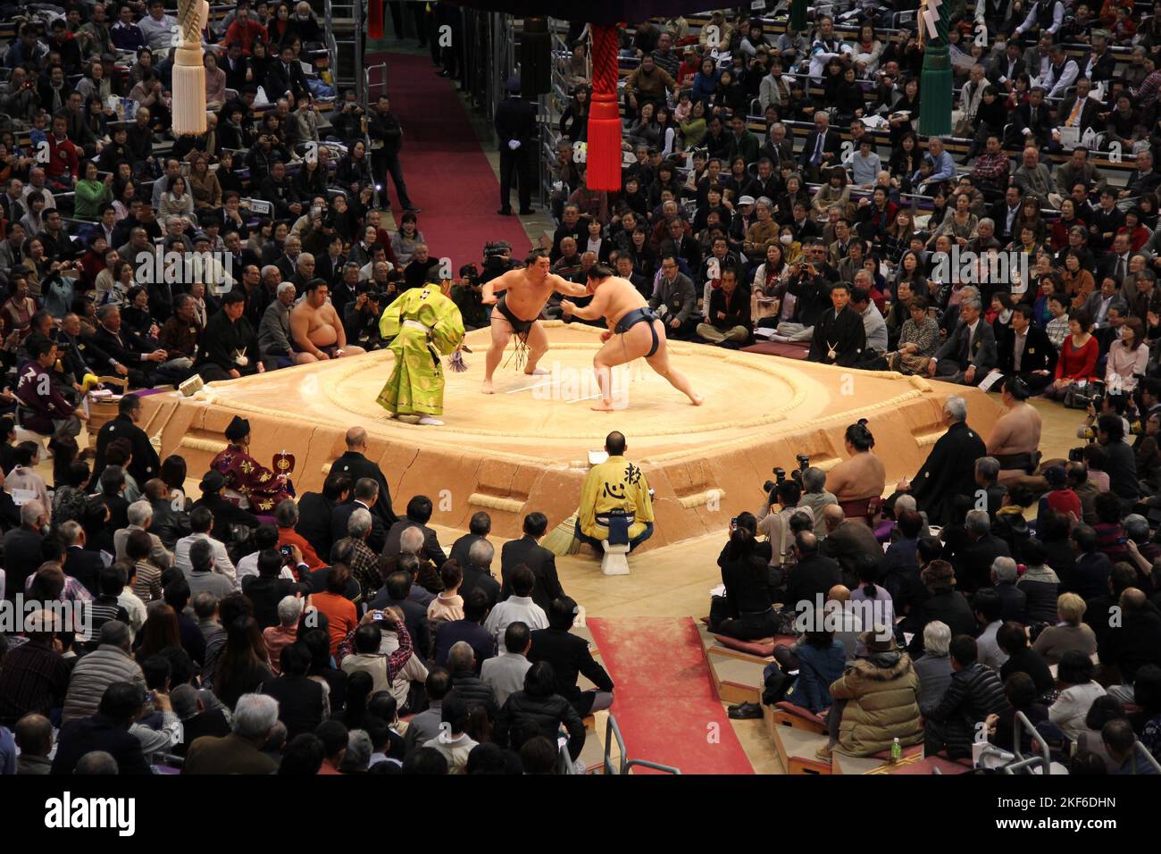 In Fukuoka treten Sumo-Wrestler mit einem Weitwinkelschuss vor Publikum in einer Meisterschaft an Stockfoto