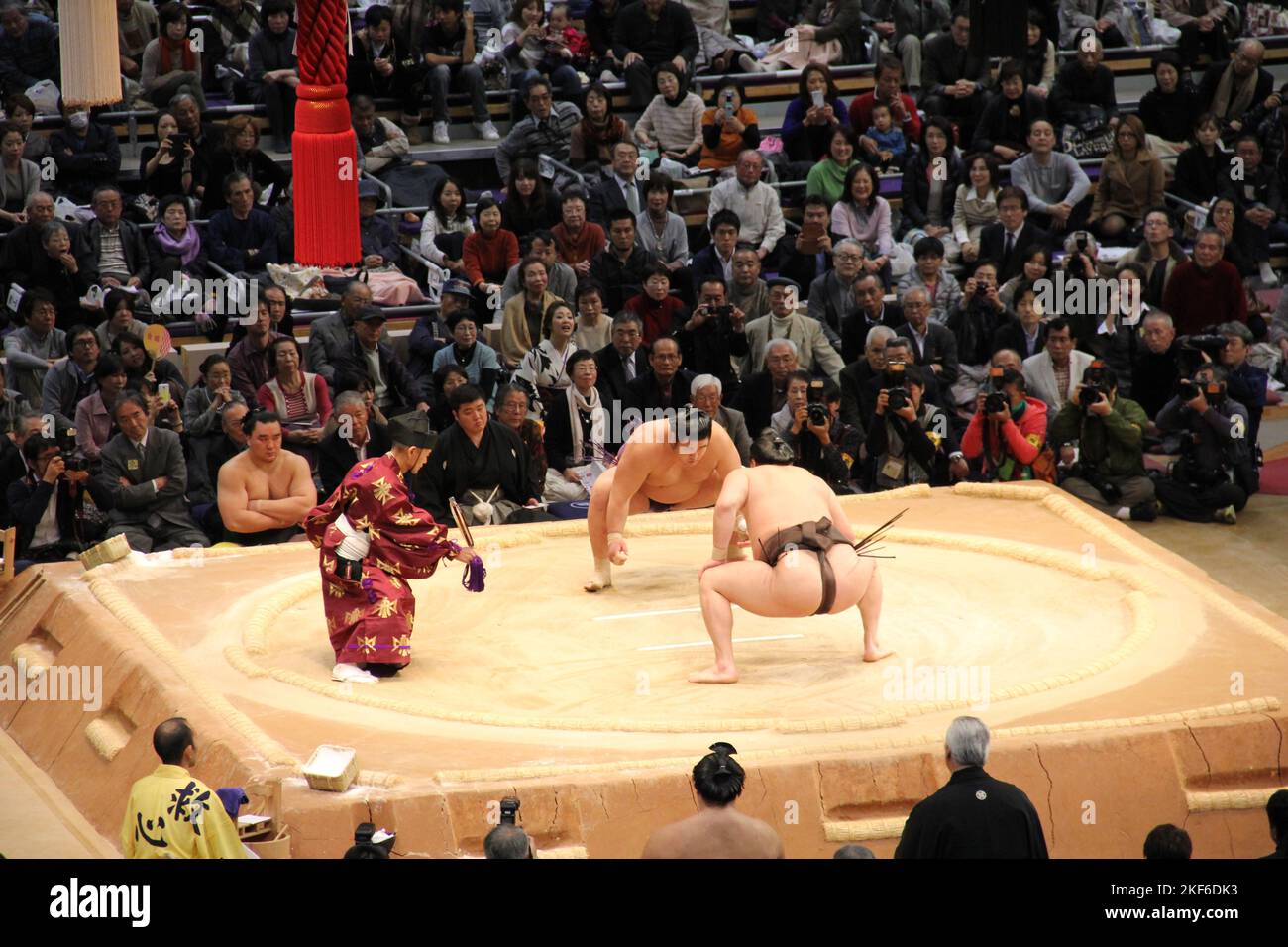 In Fukuoka treten Sumo-Wrestler mit einem Weitwinkelschuss vor Publikum in einer Meisterschaft an Stockfoto