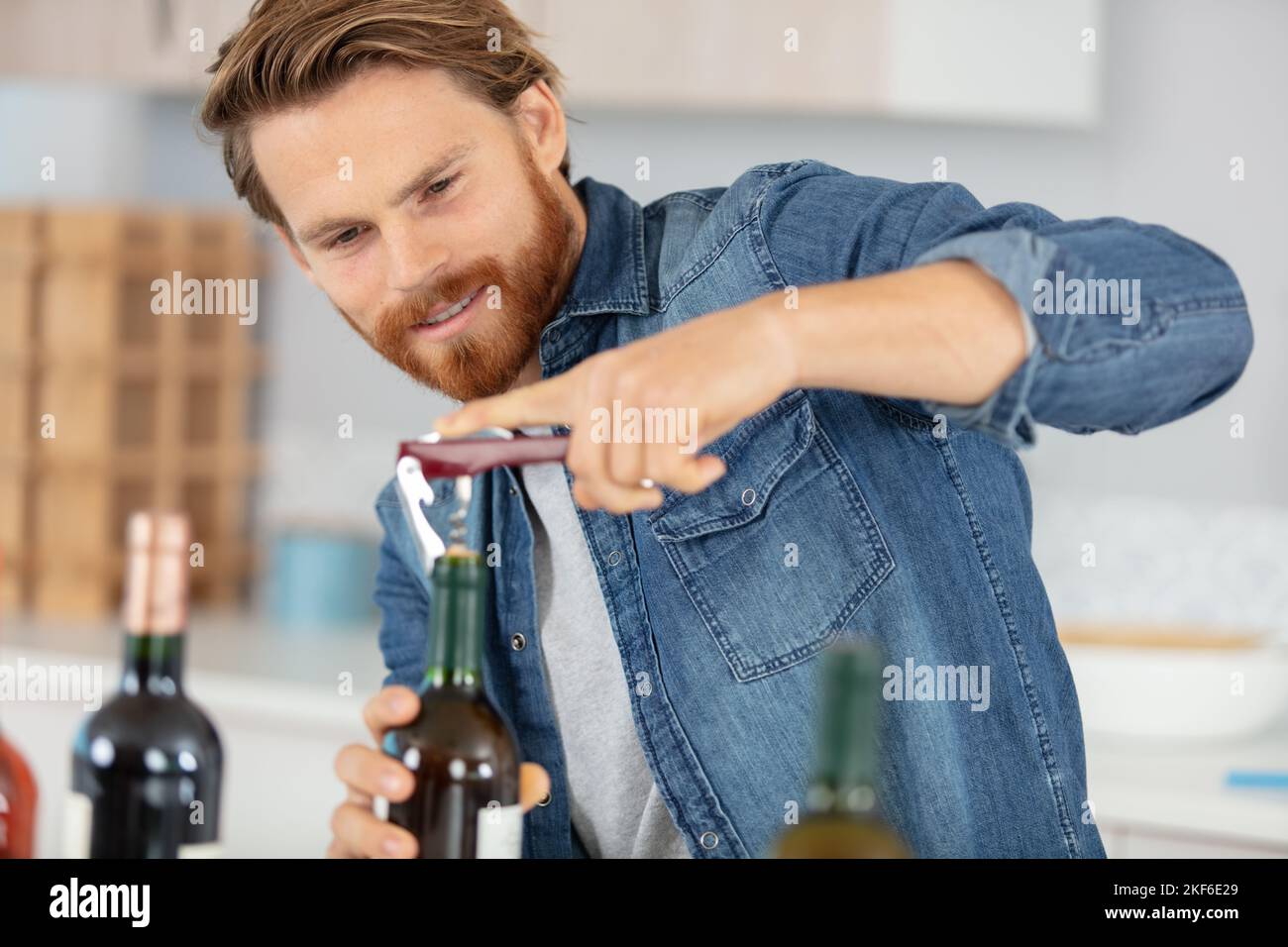 Männlicher Sommelier, offene Weinflasche mit Korkenzieher Stockfoto