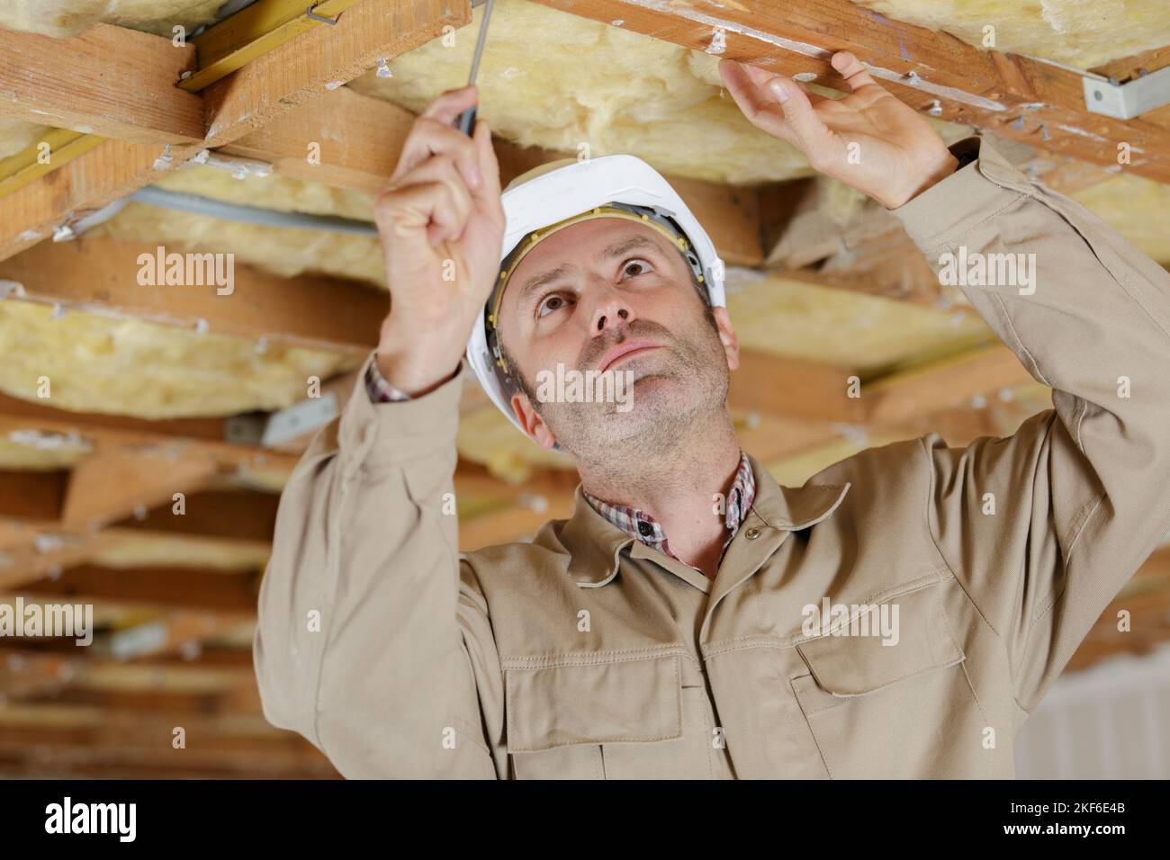 baumeister arbeitet an Holzdecke Stockfoto