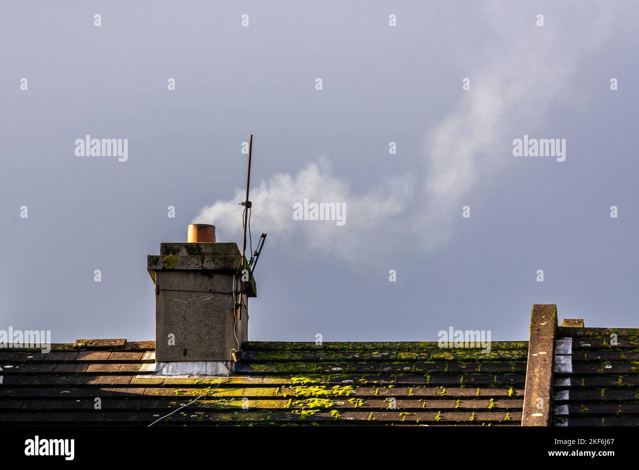Rauch steigt aus einem Hauschornstein in Irland. Stockfoto