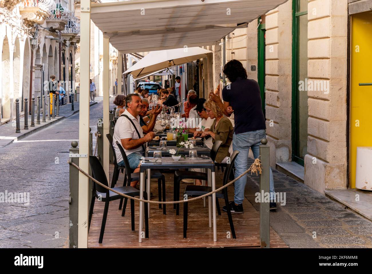 Kunden sitzen beim Mittagessen vor einem Restaurant in Ortigia, Syrakus (Siracusa), Sizilien, Italien Stockfoto