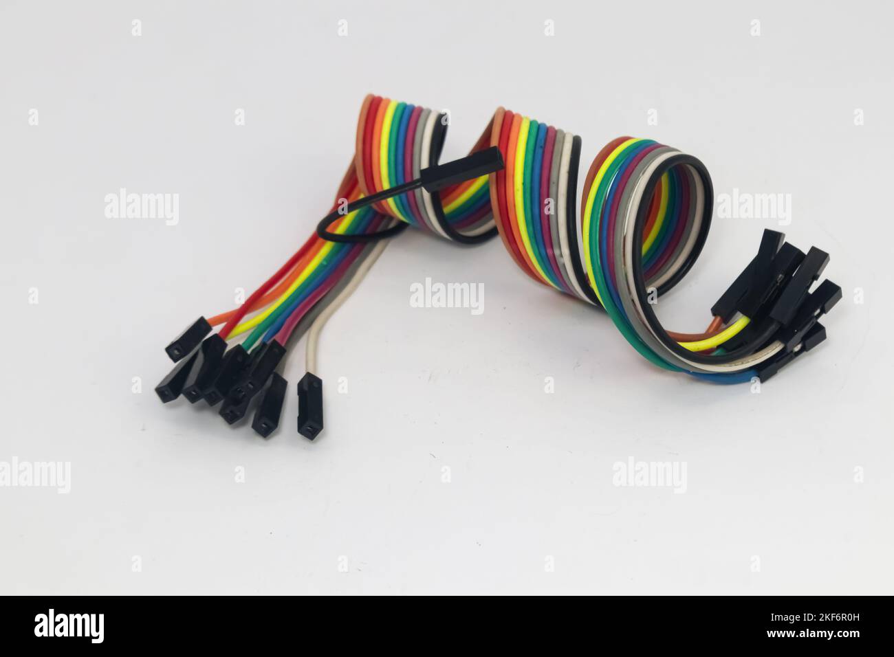 Das Rainbow-Kabel ist in einer Spirale mit einem Buchse-Buchse-Steckverbinder als Jumper für DIY-Materialien geformt. Stockfoto