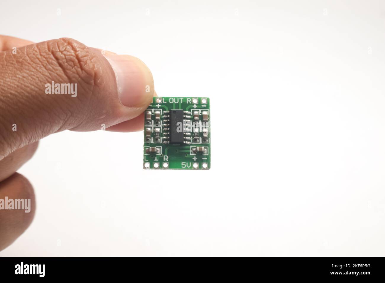 Ein kleines Audioverstärkermodul, das in einer Hand gehalten wird, dient als DIY-Material für den Elektronikbastler. Stockfoto