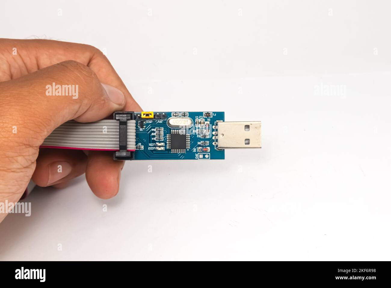 Ein AVR Mikrocontroller USB Downloader in einer Hand gehalten. Stockfoto