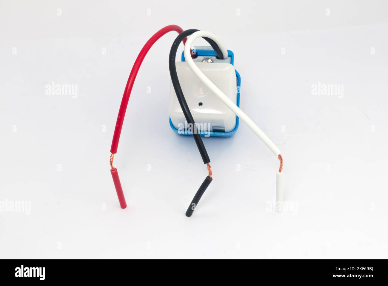 Drei farbige Drähte für die automatische Straßenlichtsteuerung auf weißem Hintergrund. Stockfoto