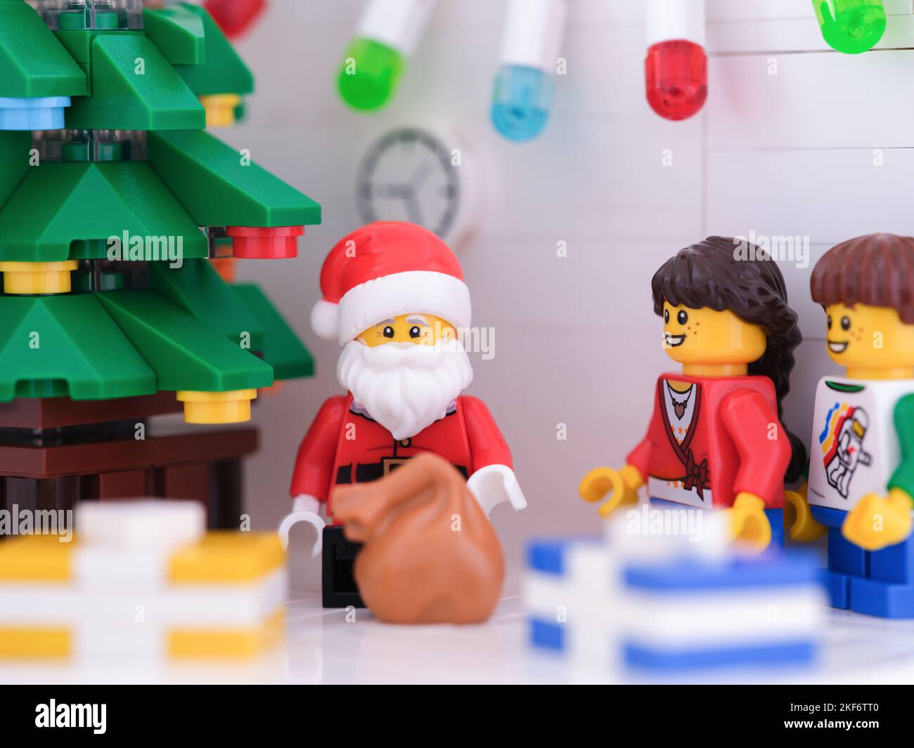 Tambov, Russische Föderation - 15. November 2022 Lego Weihnachtsmann und Kinder Minifiguren stehen in der Nähe eines Weihnachtsbaums mit Geschenken um ihn herum. Stockfoto