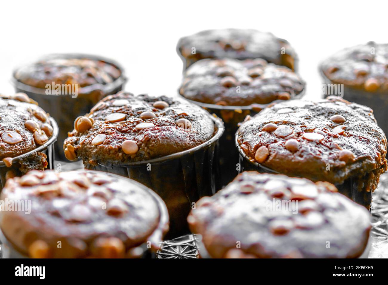 Muffins mit Schokoladenchips hausgemachte Makrofotografie aus der Nähe, weißes Sonnenlicht von der Seite. Selektiver Fokus mit geringer Tiefenschärfe. Stockfoto