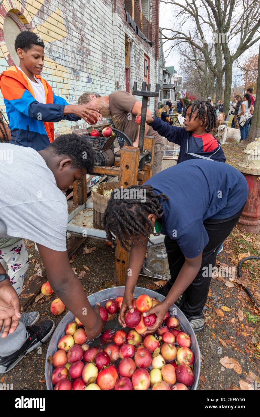 Detroit, Michigan - Junge Leute machen Apfelwein mit einer Apfelpresse auf einem Herbstfestival auf der nahen Ostseite von Detroit. Stockfoto