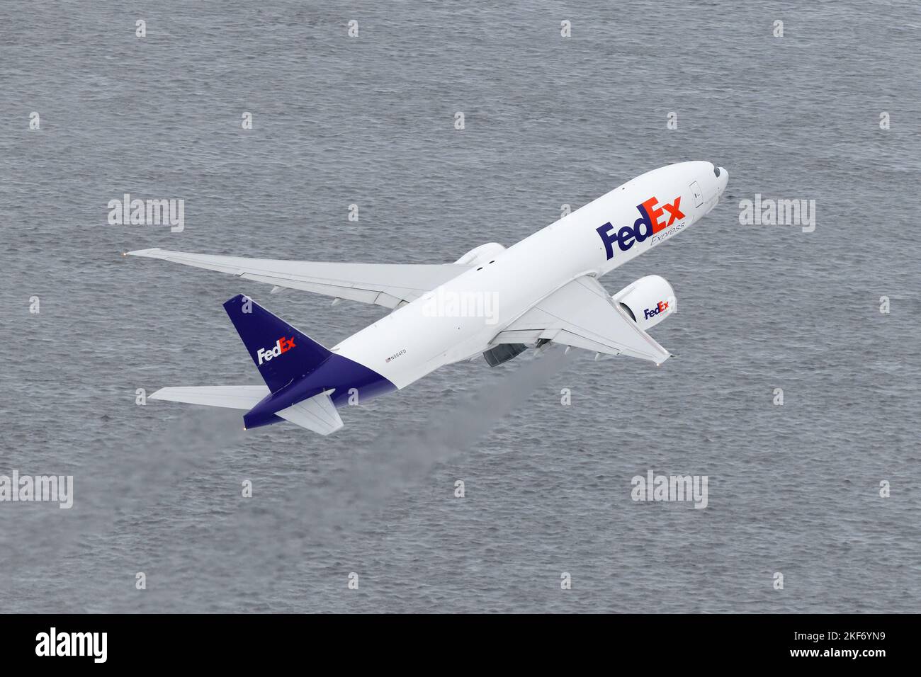 FedEx Boeing 777 startet. Flugzeug 777F für den Frachttransport mit Federal Express, das von der Start- und Landebahn abfährt. Das Flugzeug startet von oben. Stockfoto