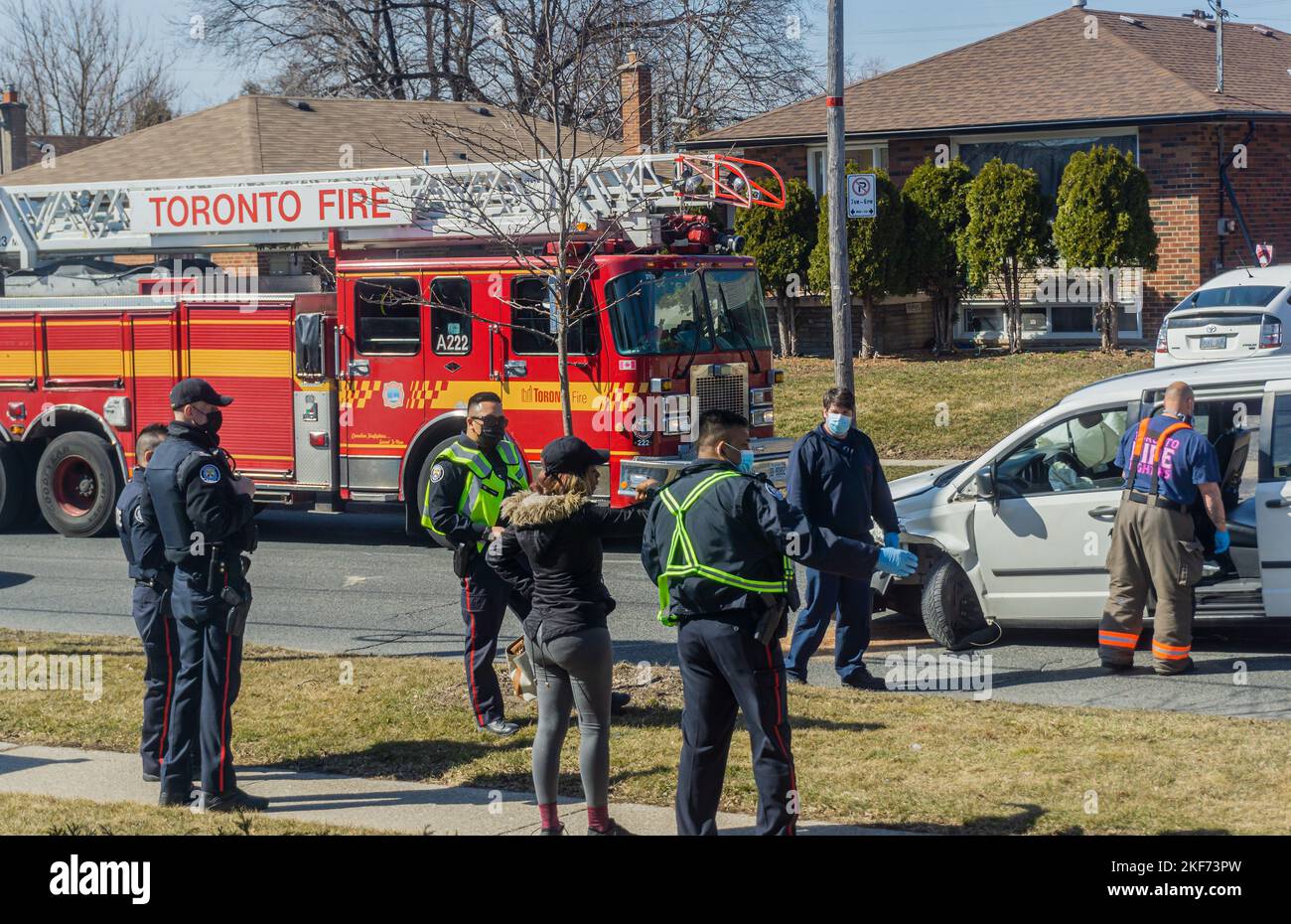 Toronto, Kanada, März 2021 - Polizeibeamte und Feuerwehrfahrzeuge um ein Fahrzeug, das in einen Unfall verwickelt ist Stockfoto