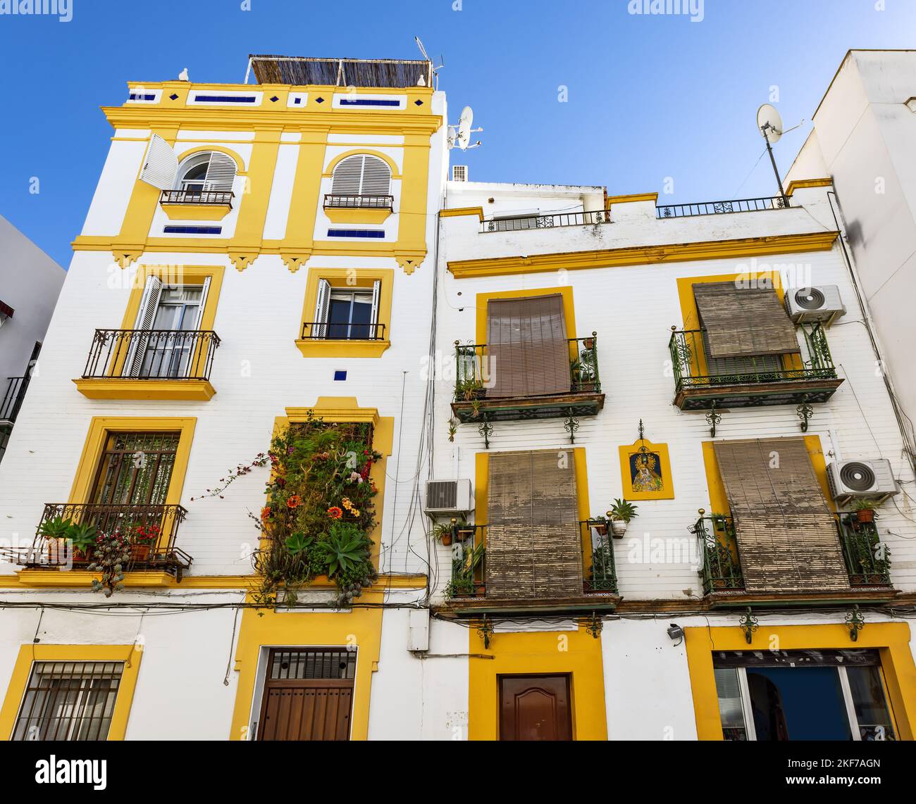 Gelb-weißes Gebäude mit schönen Balkonen im historischen Zentrum von Sevilla, Andalusien, Spanien Stockfoto