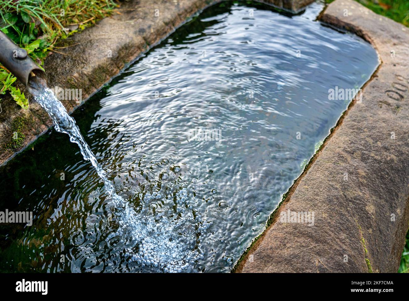Traditionelle Steinwanne als Fointain mit fließendem Wasser Stockfoto