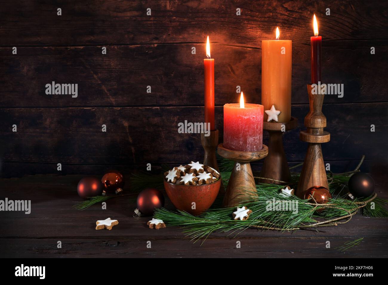 Vier Kerzen für Advent, Weihnachtsdekoration, Zimtsterne und Kiefernzweige vor dunklem rustikalem Holzhintergrund, Kopierraum, ausgewählter Fokus Stockfoto