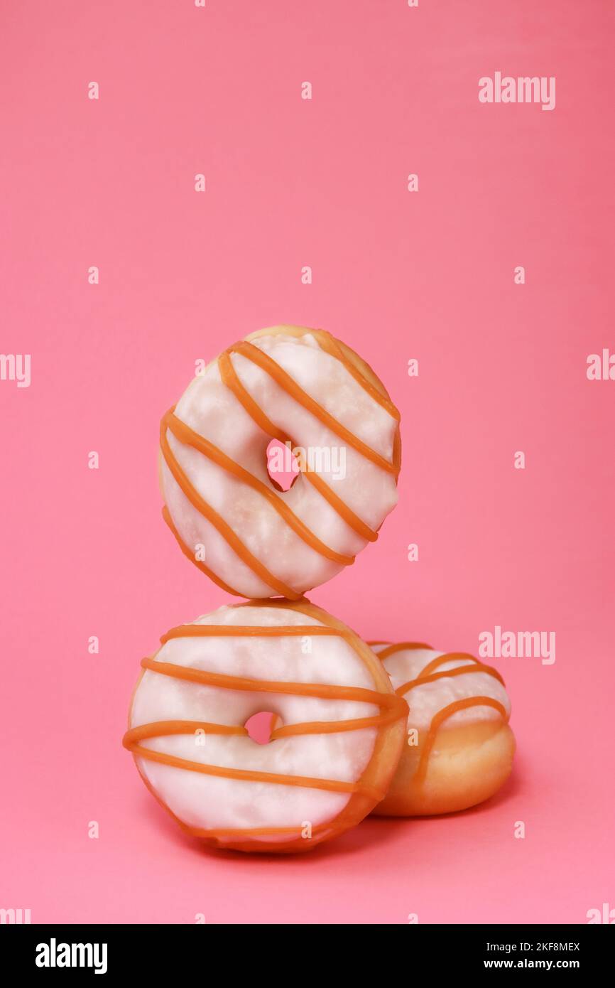 Mini-Donuts mit weißer Glasur auf rosa Hintergrund Stockfoto