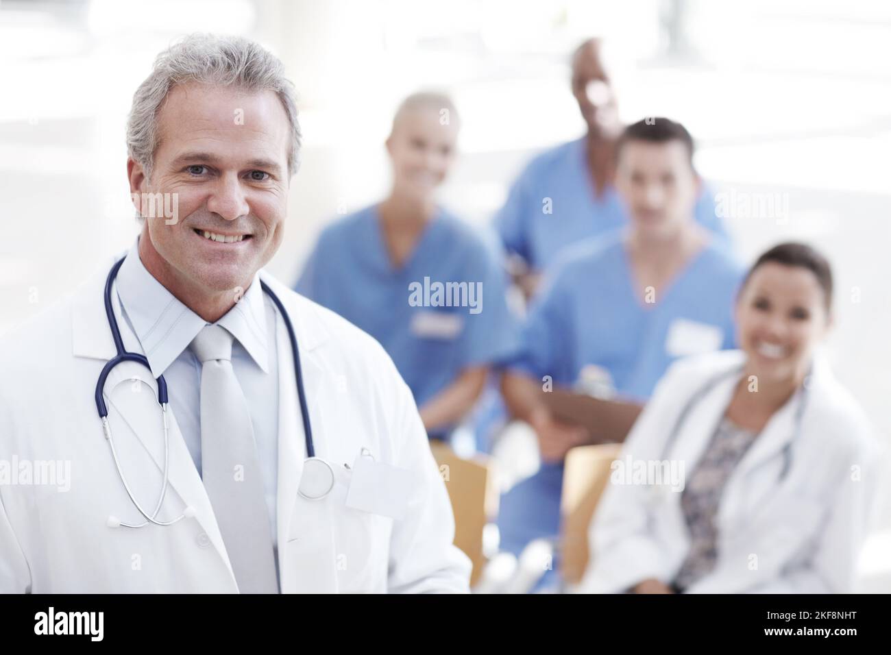 HES ist ein führendes Unternehmen im Gesundheitswesen. Ein Arzt steht mit Kollegen im Hintergrund. Stockfoto